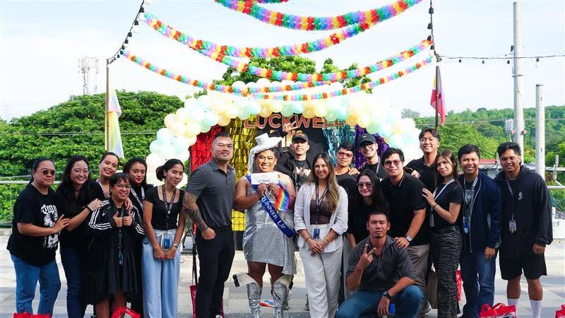 A group posing together at an outdoor celebration beneath colorful decorations.